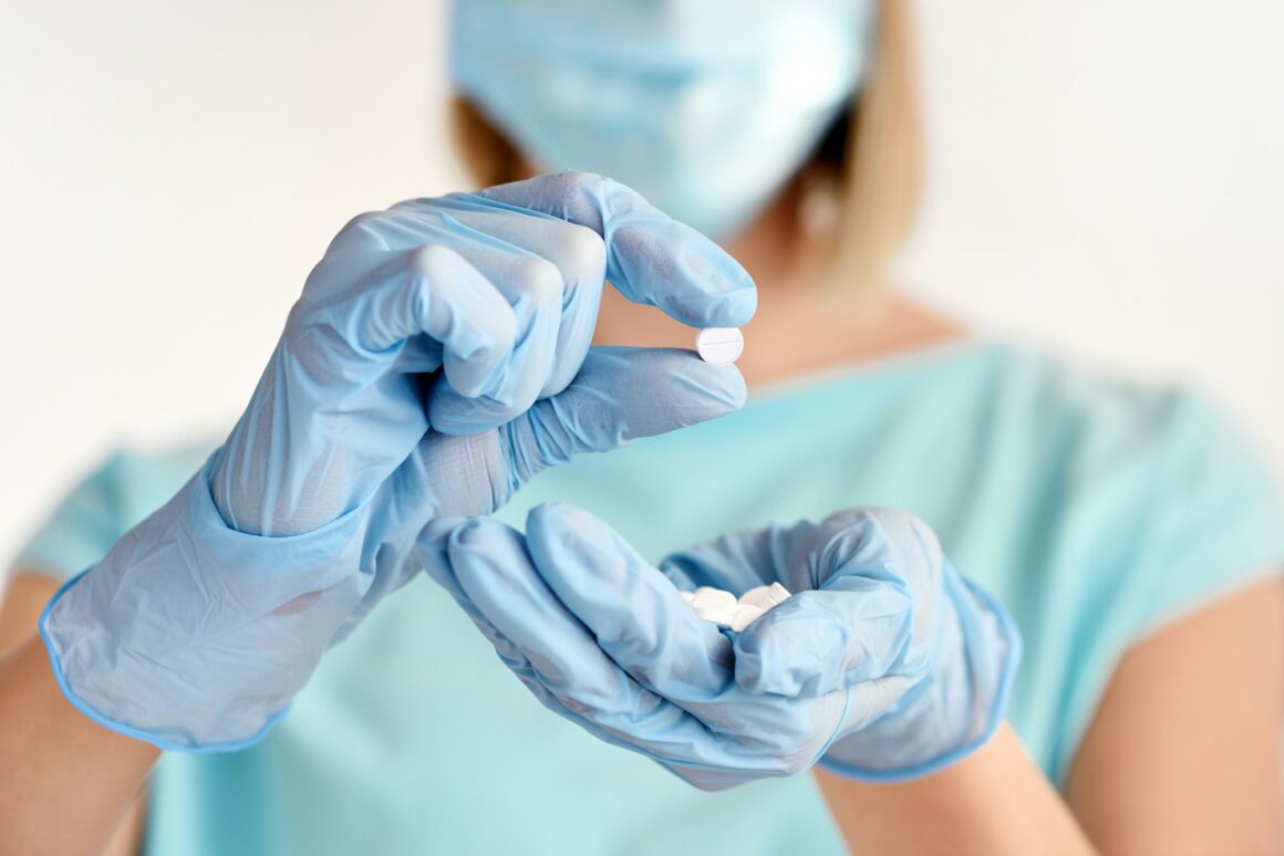 Hand of a doctor shows the pill to be taken to her patient. Healthcare and medical concept.