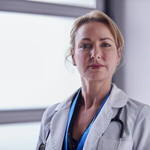 Portrait Of Mature Female Doctor Wearing White Coat In Hospital